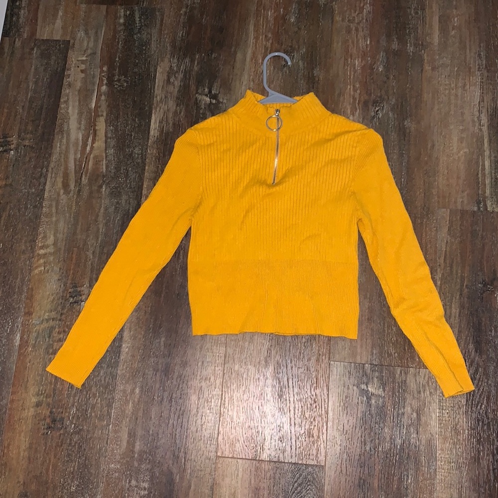 Yellow long sleeved turtle neck shirt.